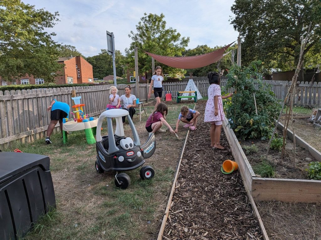 Children playing and exploring in an outdoor community garden and play area